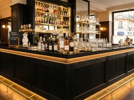 Comptoir de bar lumineux en chêne noir dans une brasserie française