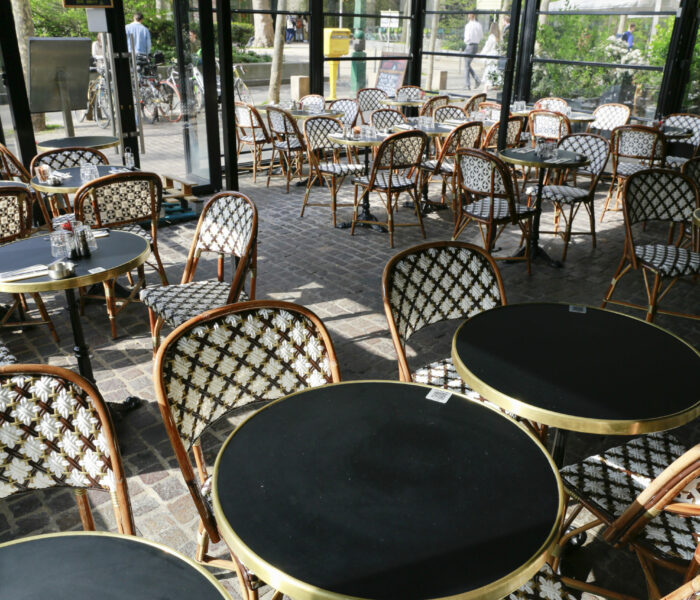 Restaurant parisien avec sa superbe terrasse composée de chaises en rotin et tables bistrot
