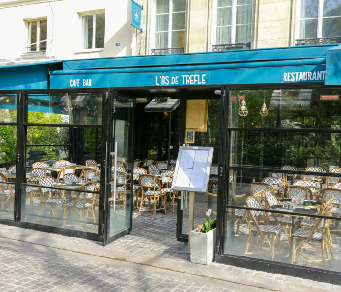 l'As de Trèfle restaurant parisien aménagé avec sa terrasse de chaises en rotin sur mesure